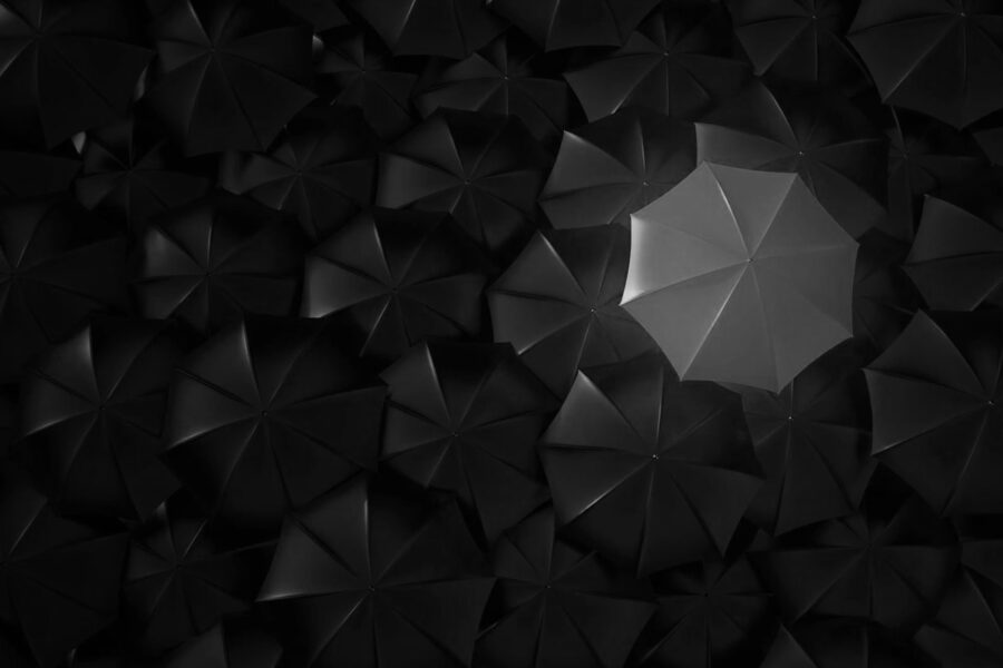 An orange umbrella standing out in a sea of other umbrellas